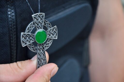 Cruz celta colgante de acero con centro verde.